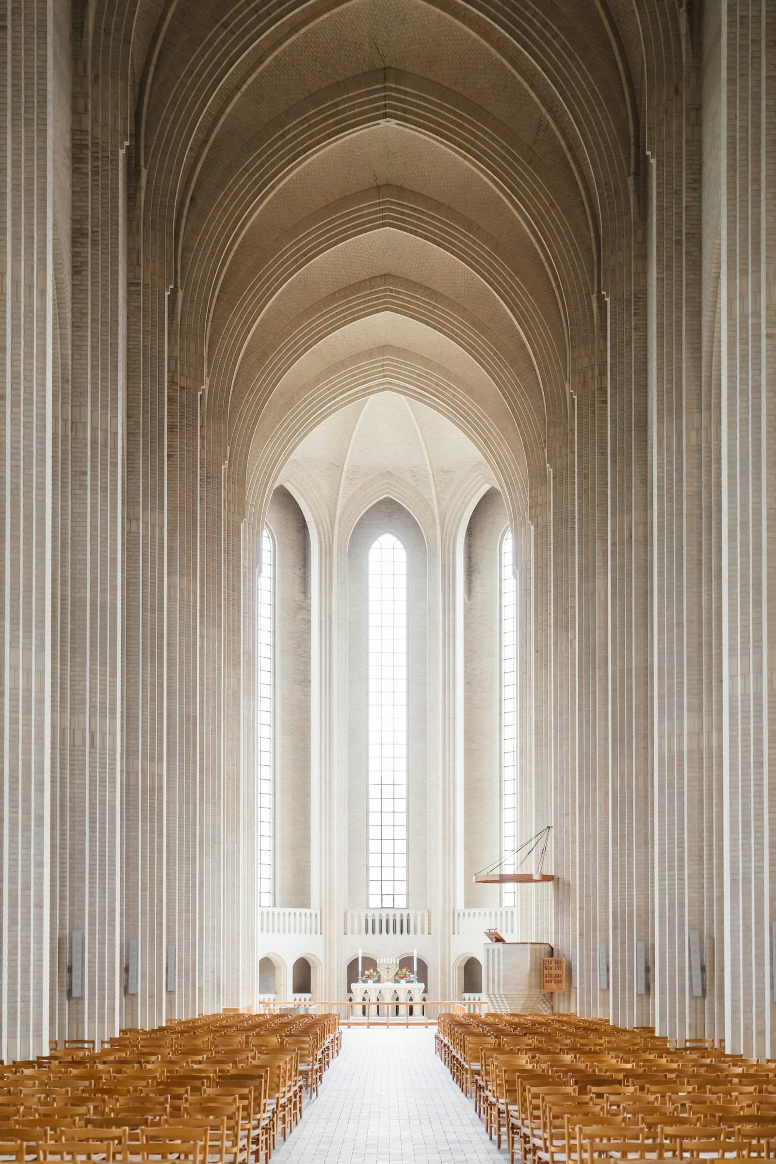 Empty cathedral interior showing pews, columns and vaulted ceiling