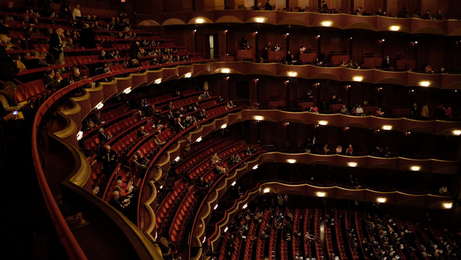Audience seated inside a concert hall during an orchestral performance, evoking the Proms at the Royal Albert Hall
